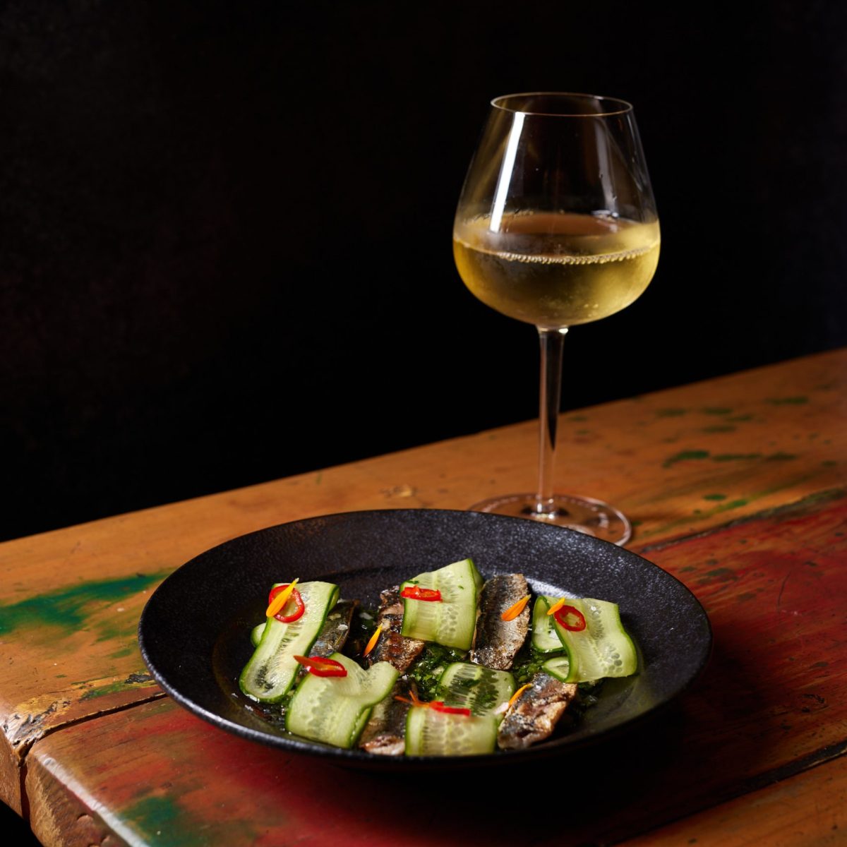 Dish of trout and a glass of straw-coloured white wine.