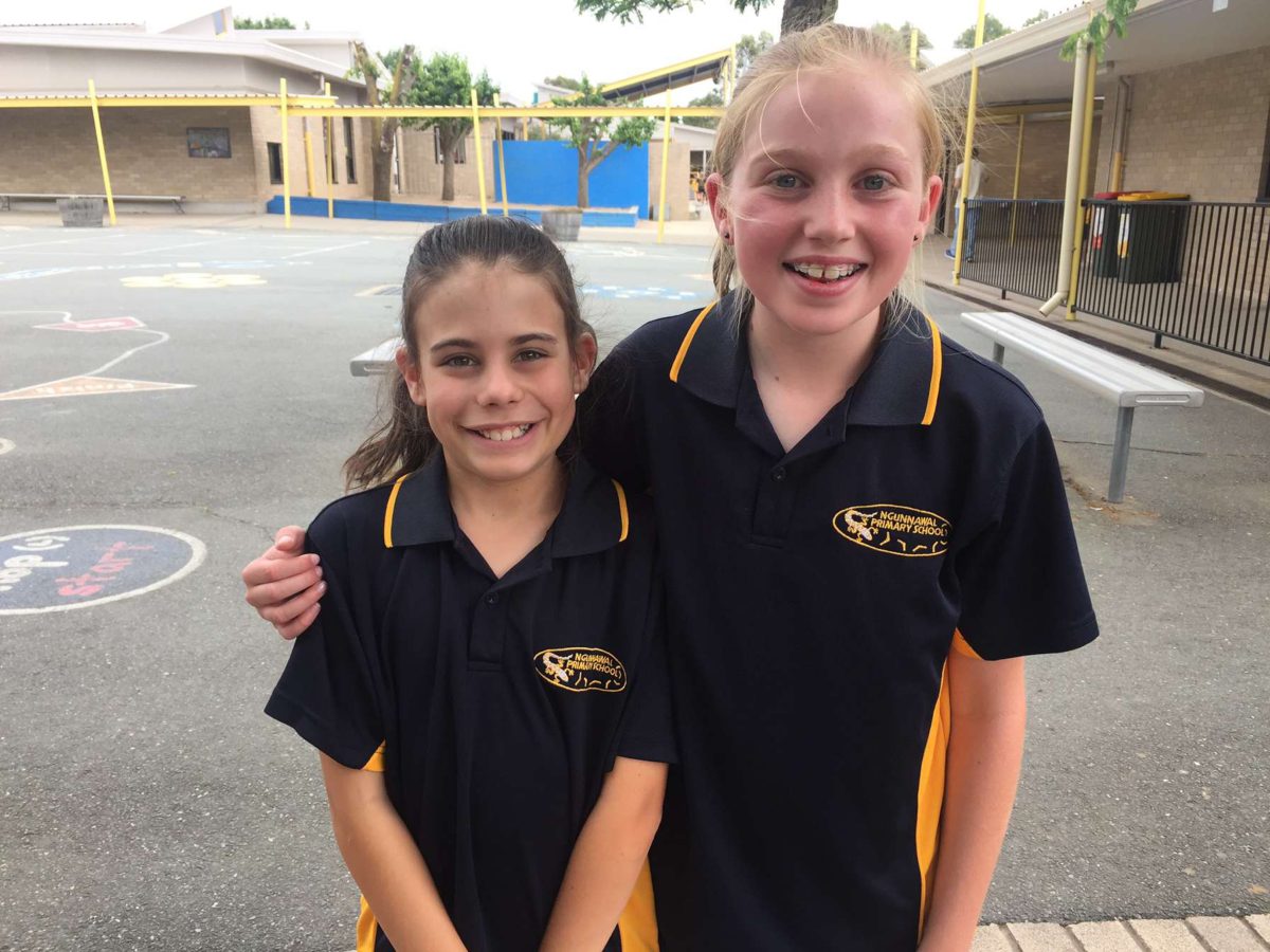 IBD advocate Madi with friend Amy in year 8 in uniform standing in the school yard