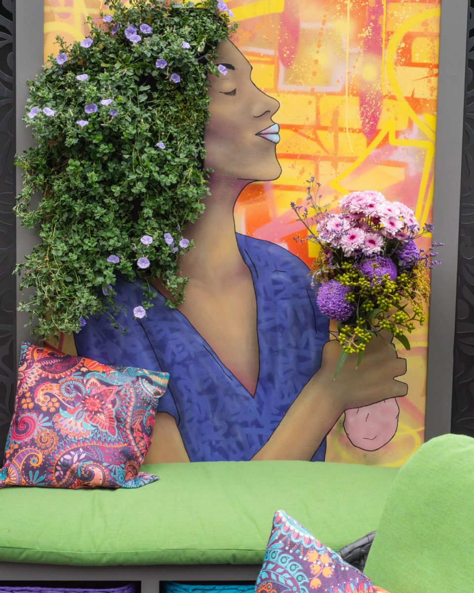 Botanicial mural of a woman who is holding flowers