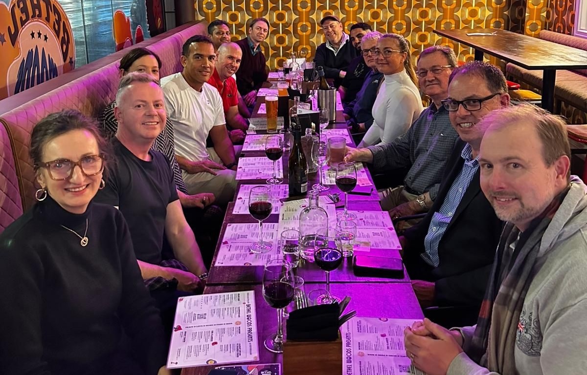 A group of people sitting at a long table in a restaurant