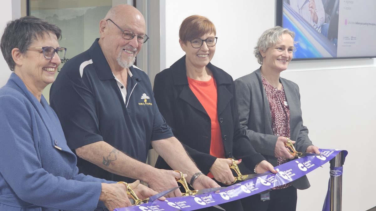 People performing a ribbon-cutting ceremony in a building
