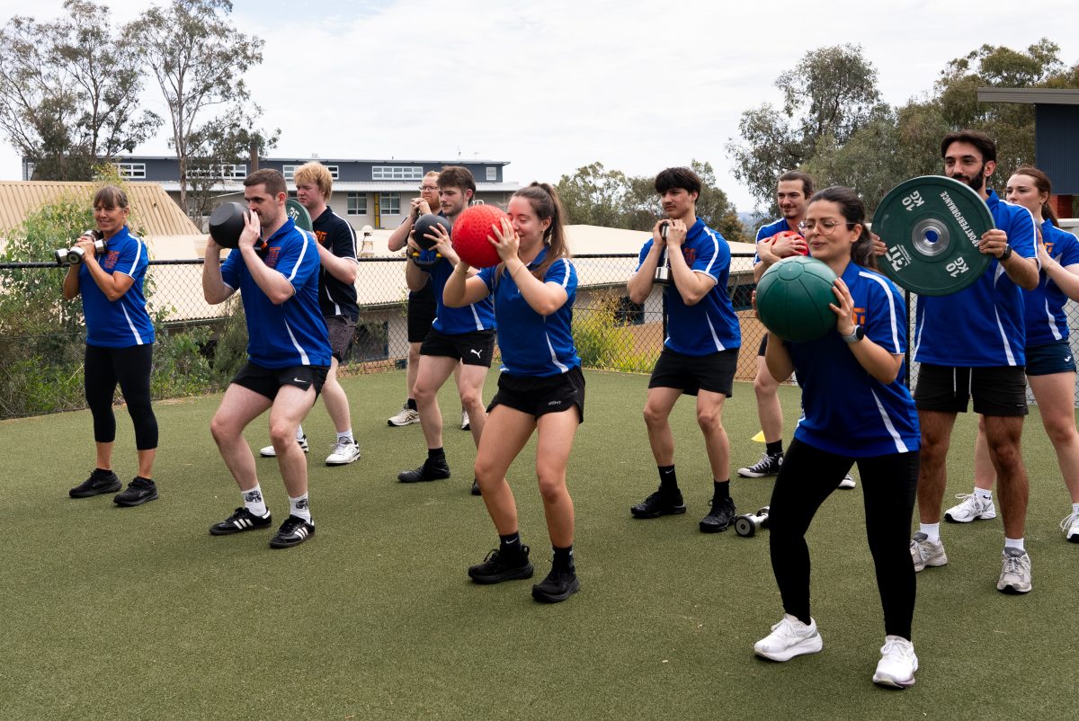 Group of students in a fitness class doing squats