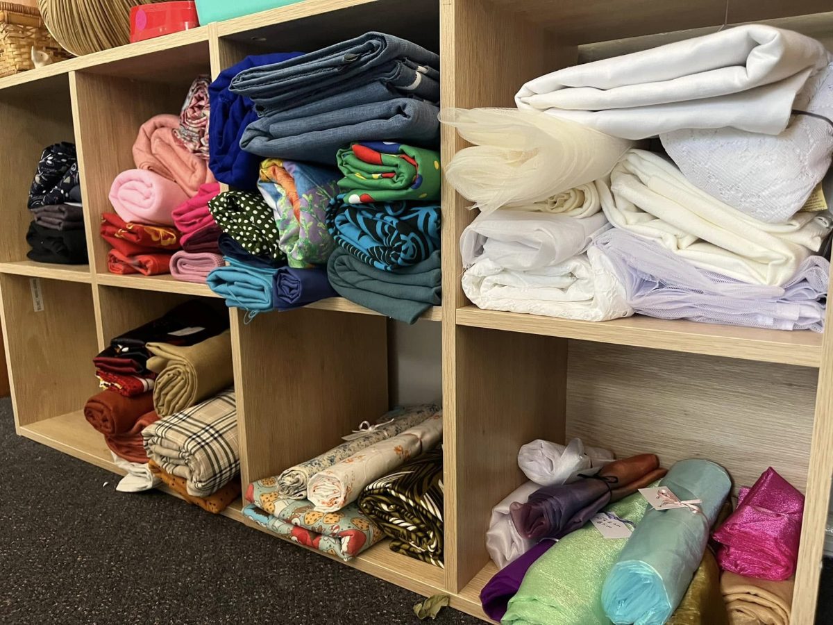 A cupboard filled with different fabrics.