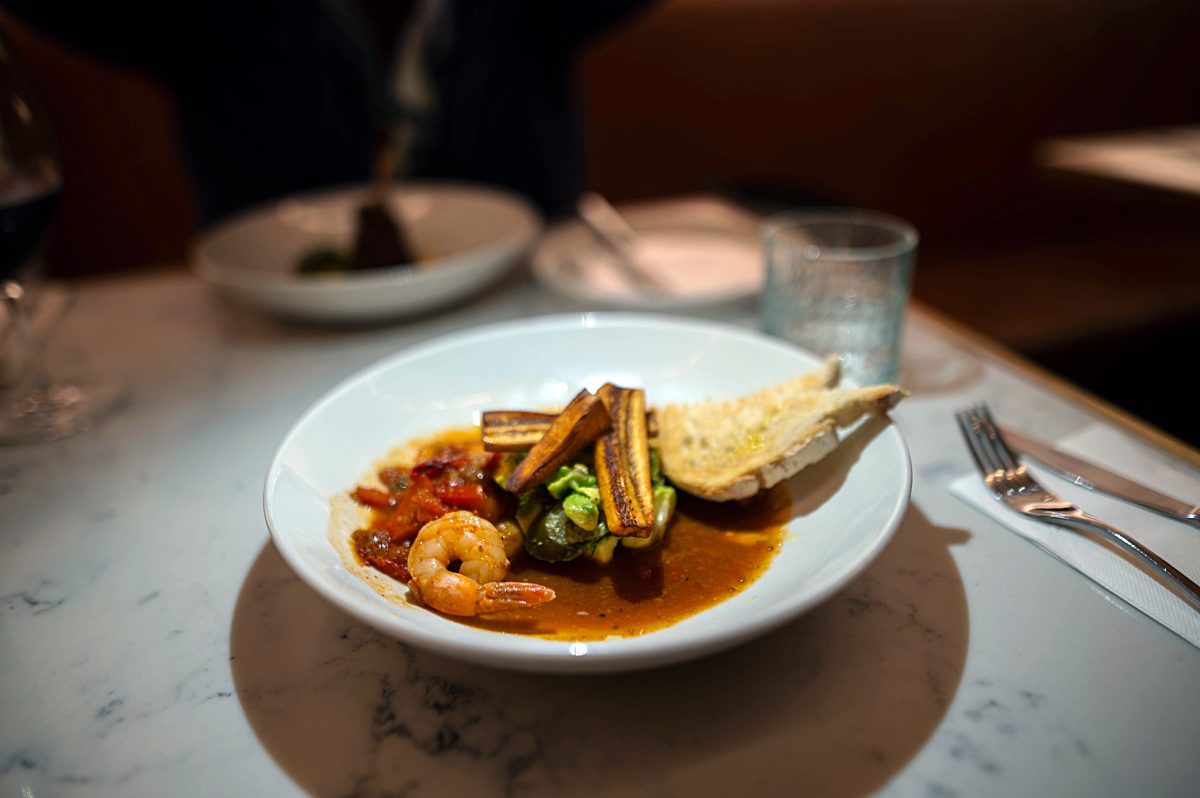 Crisp plantain slices crown a plate of prawns served with two salsas.