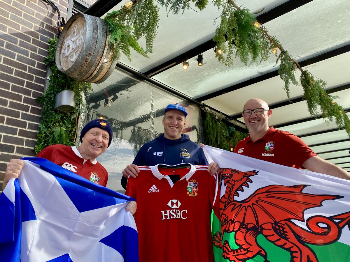 British Lions die-hard fans Dave Primrose and Jim Roy with former Wallaby Ben Alexander and British Lions flags and jersey outside The Dock