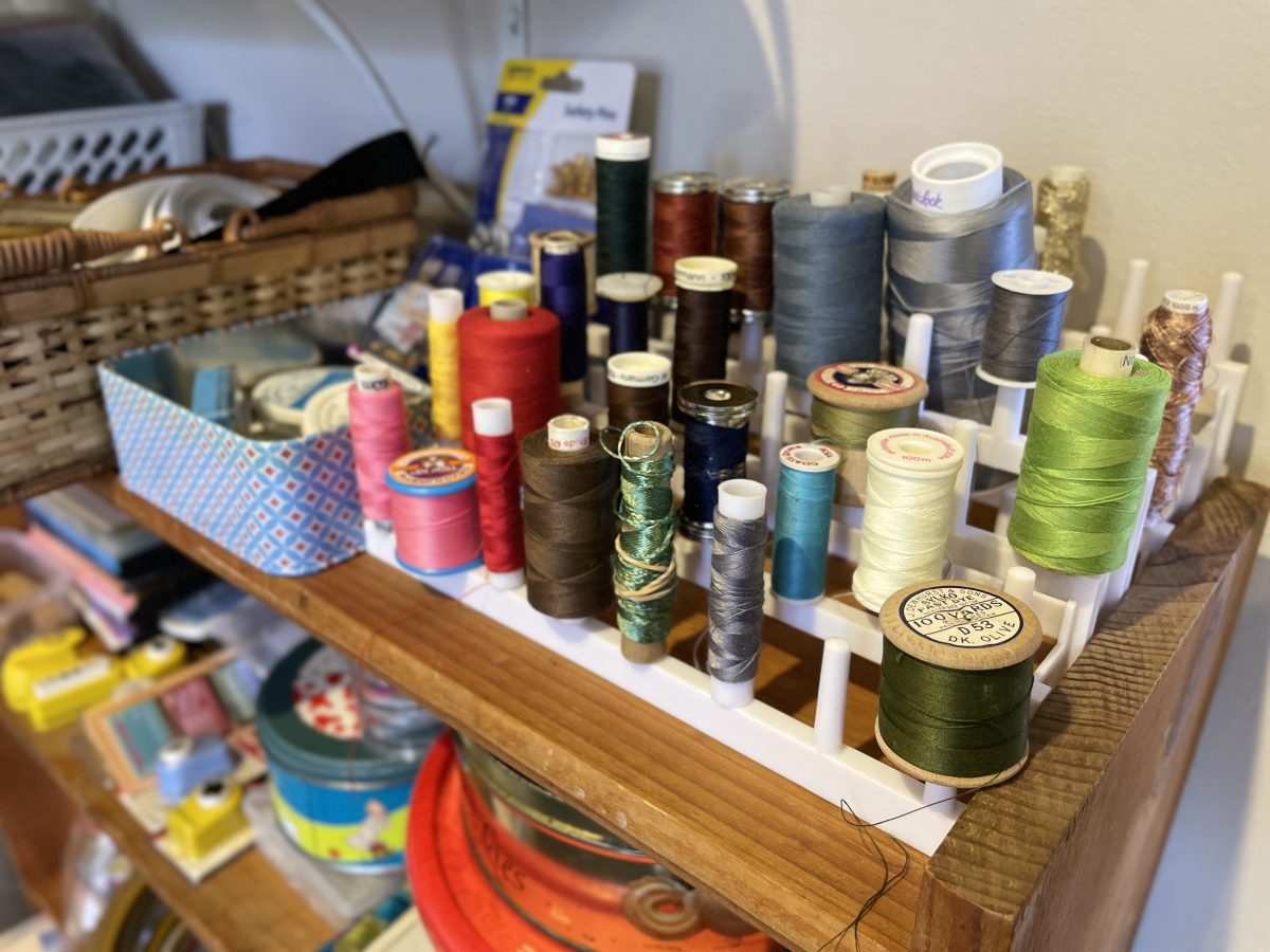 A display of different coloured threads on spools. 