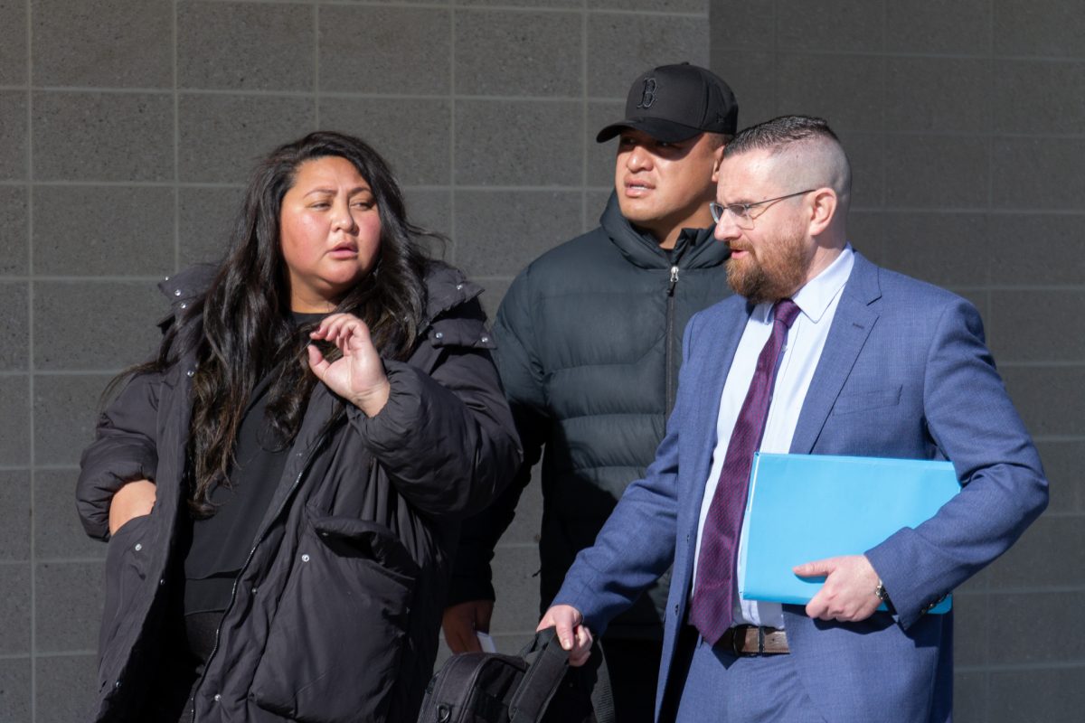 woman and two men outside court