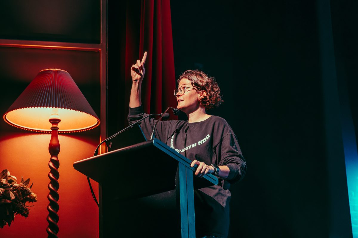 A woman standing at a podium and gesturing