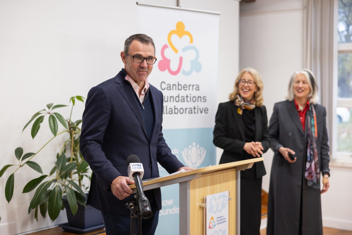 man at lectern, women standing