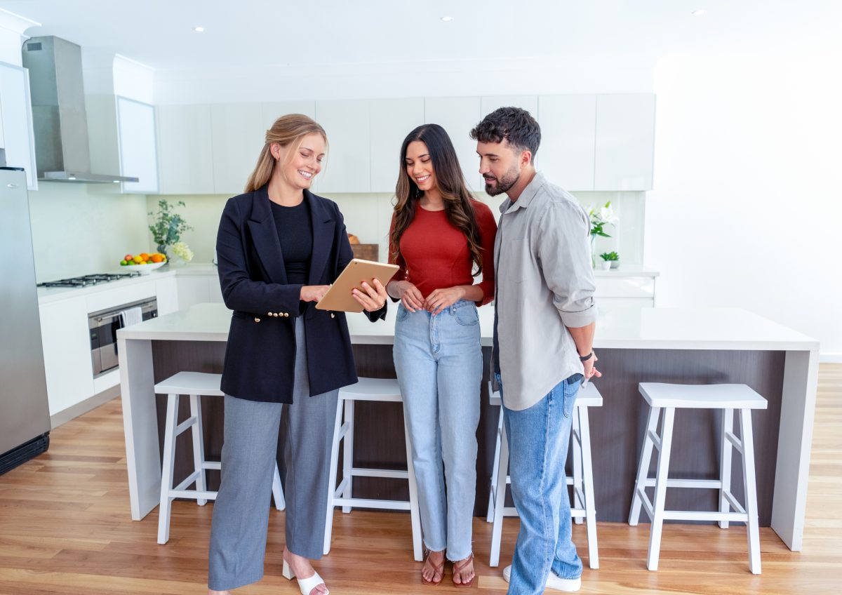 A real estate agent shows a couple a new home