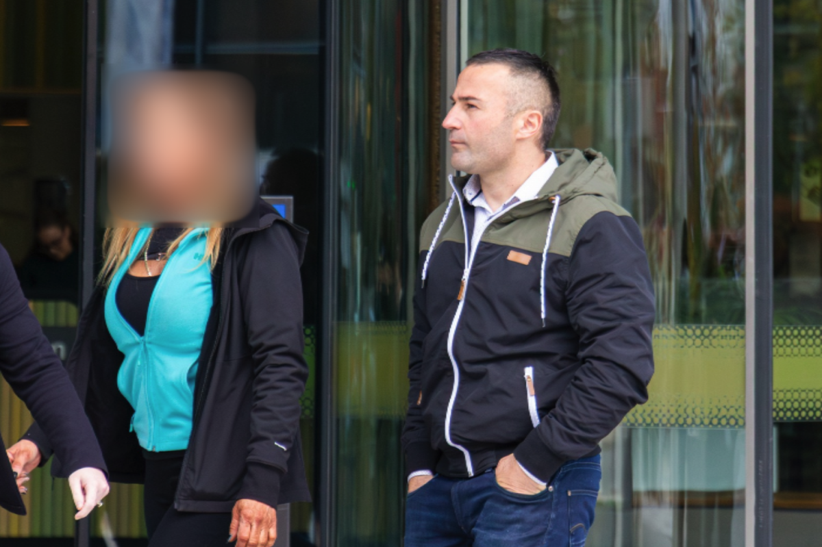 A man and a woman leaving court, with the woman's face blurred