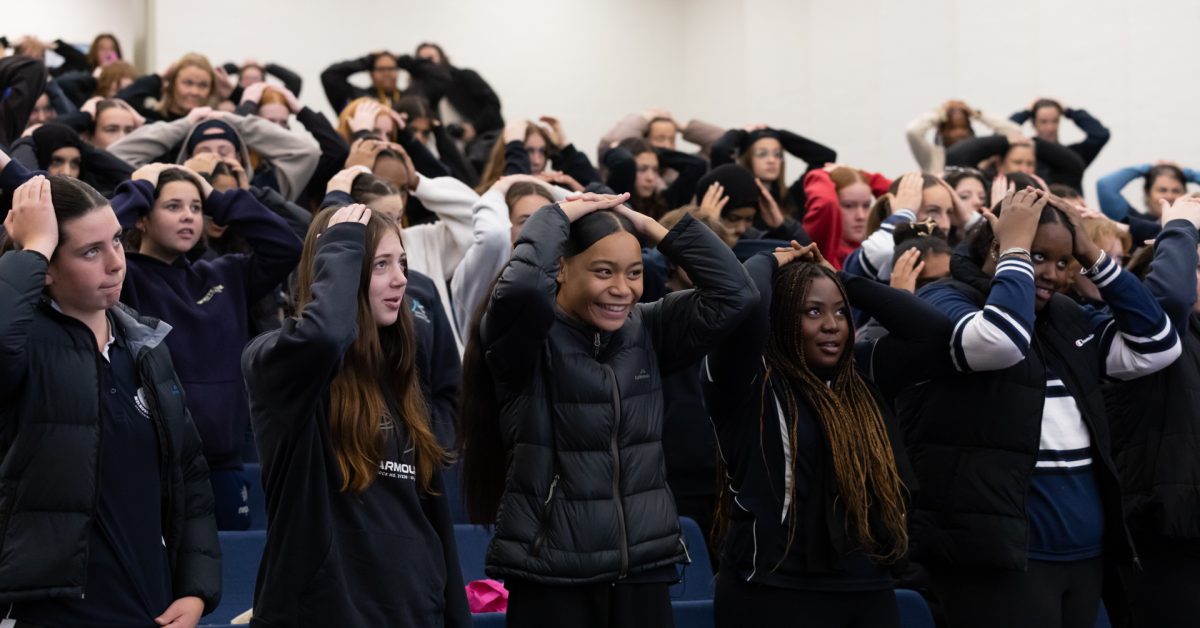 room full of participants with hands on heads