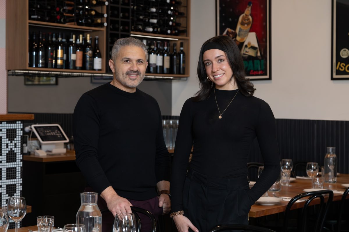 Two people standing in a restaurant and posing for the camera