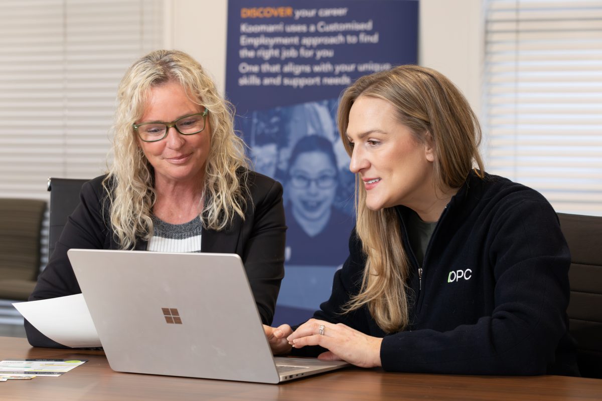 Nadine Stephen and Kate Priest sitting at a desk and looking at a laptop screen