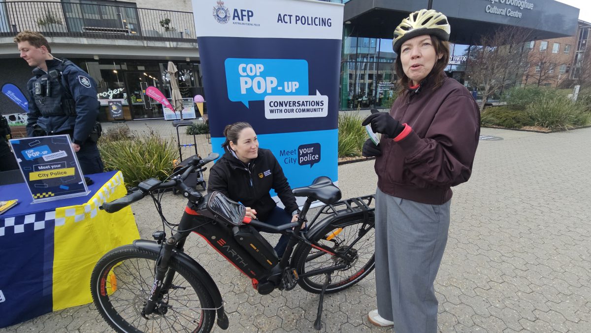A woman engraving another woman's bike