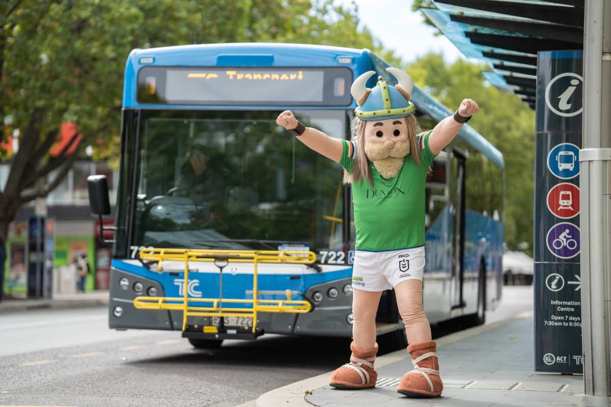Raiders Viking mascot in front of a bus