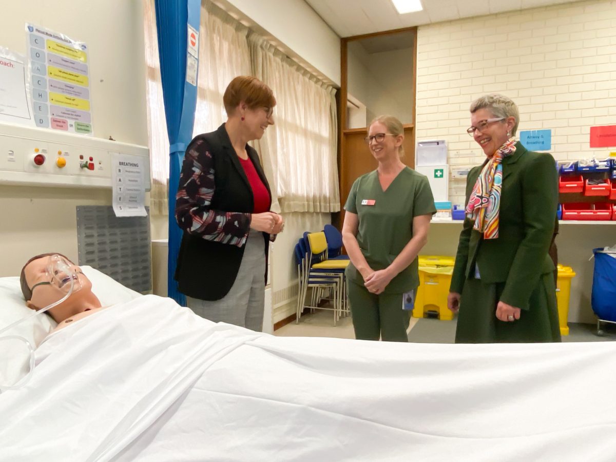women standing at nursing training bed at a hospital
