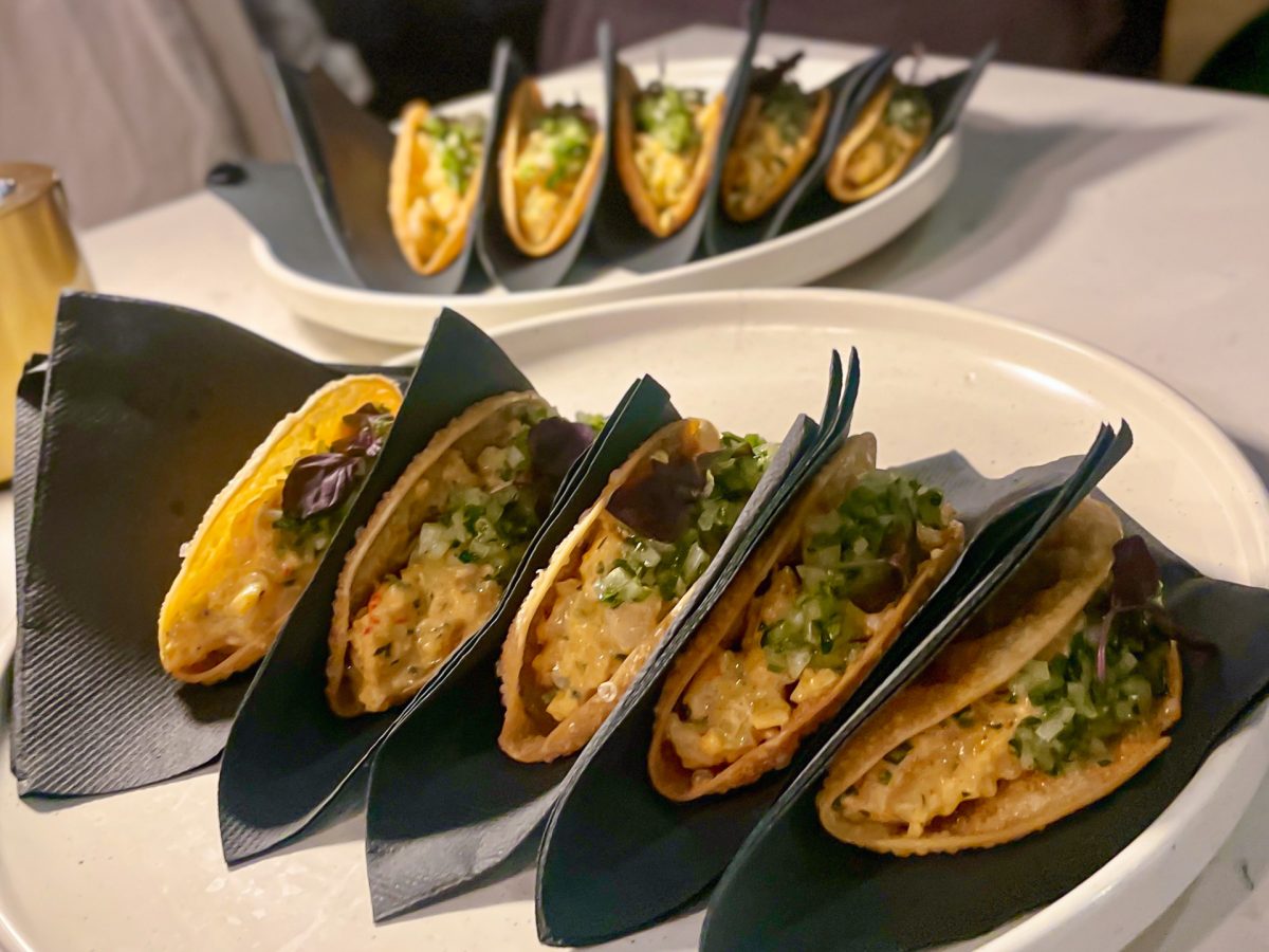 A plate of tacos in black paper napkins.