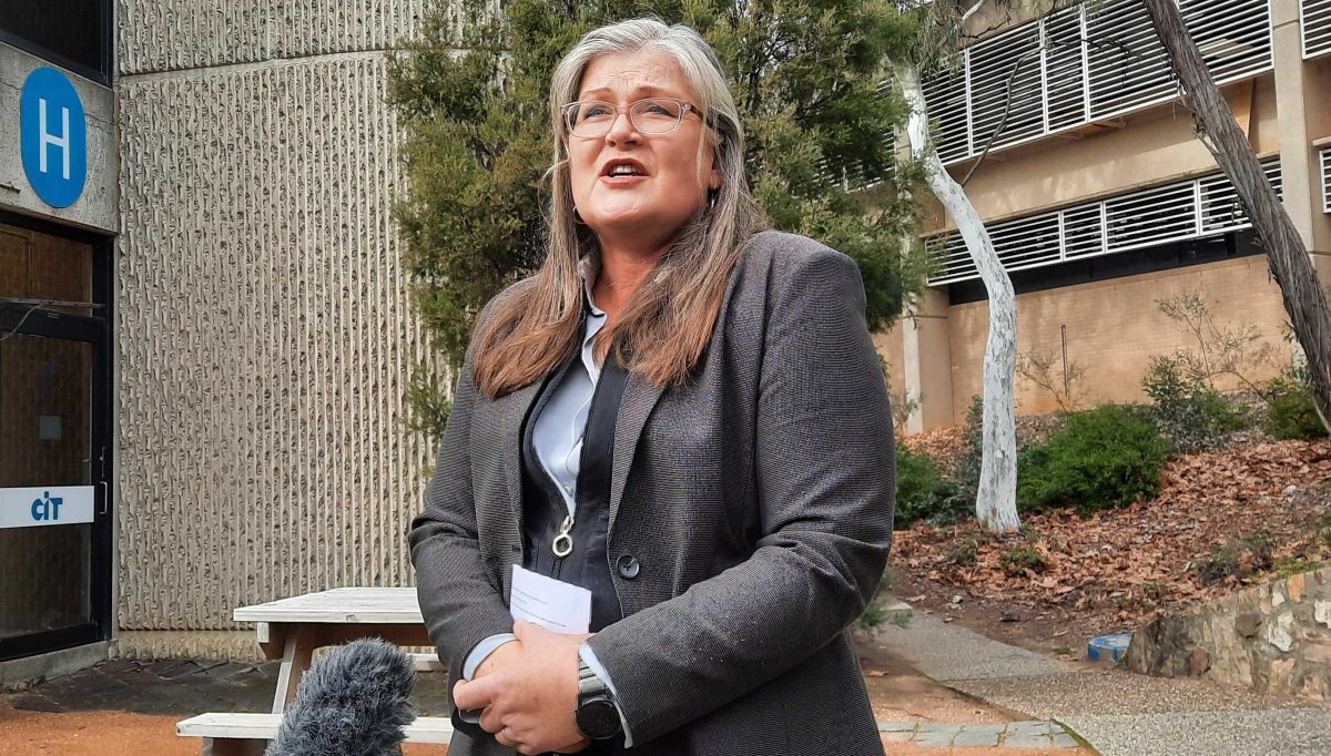 A woman giving a press conference outside