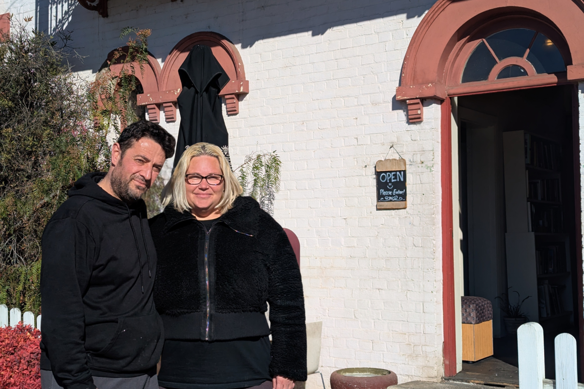 A man and woman standing in front of heritage building.