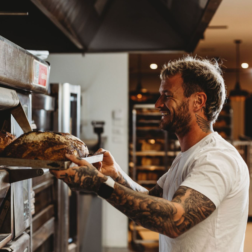 Co-owner Daniel Sparrow removes a tray of baked bread from the oven.