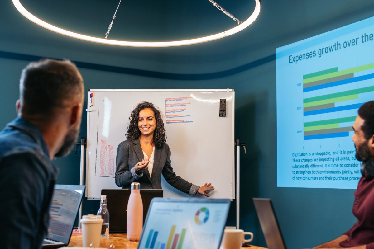Business woman leading a meeting analysing company data together with her colleagues in a modern co-working space