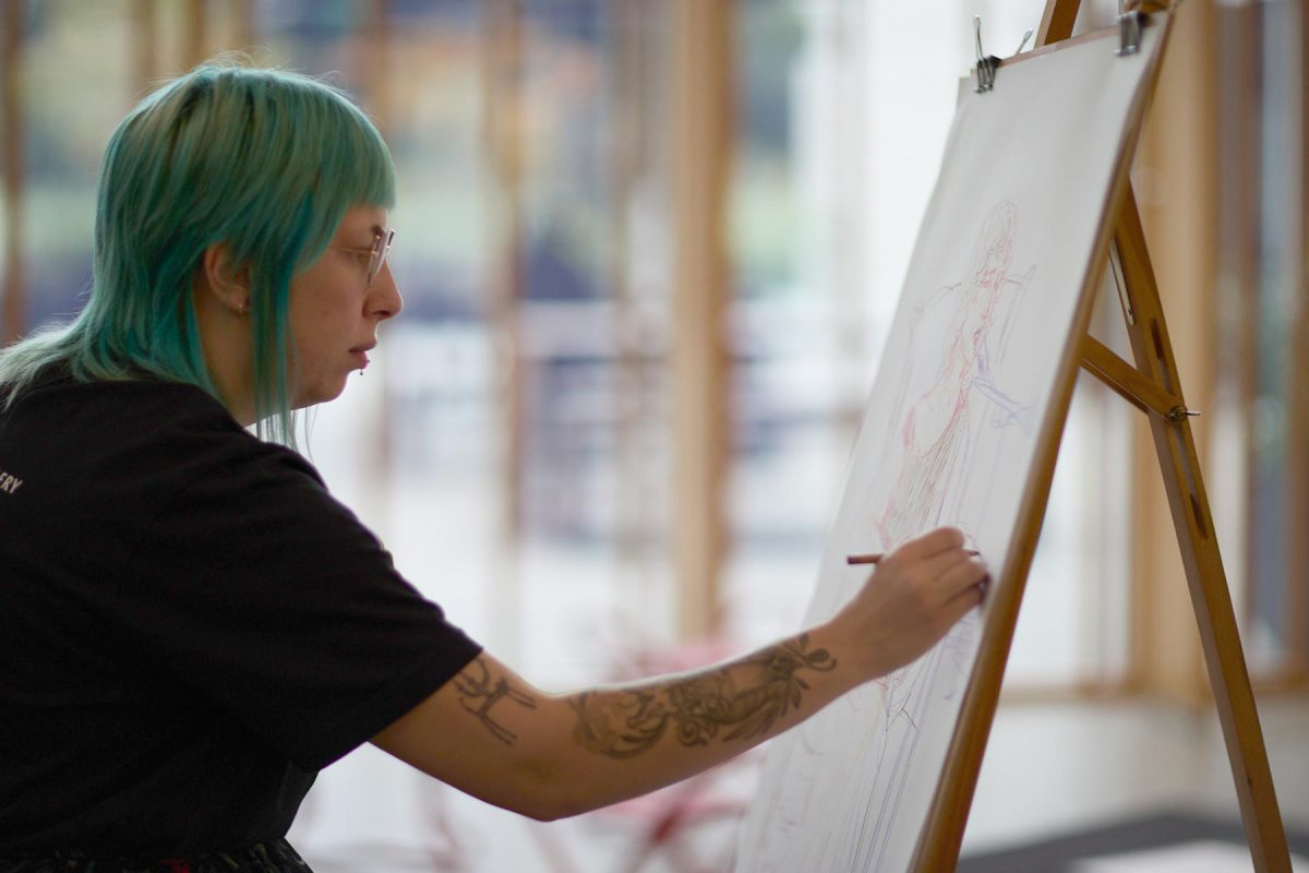 A person drawing on a large canvas