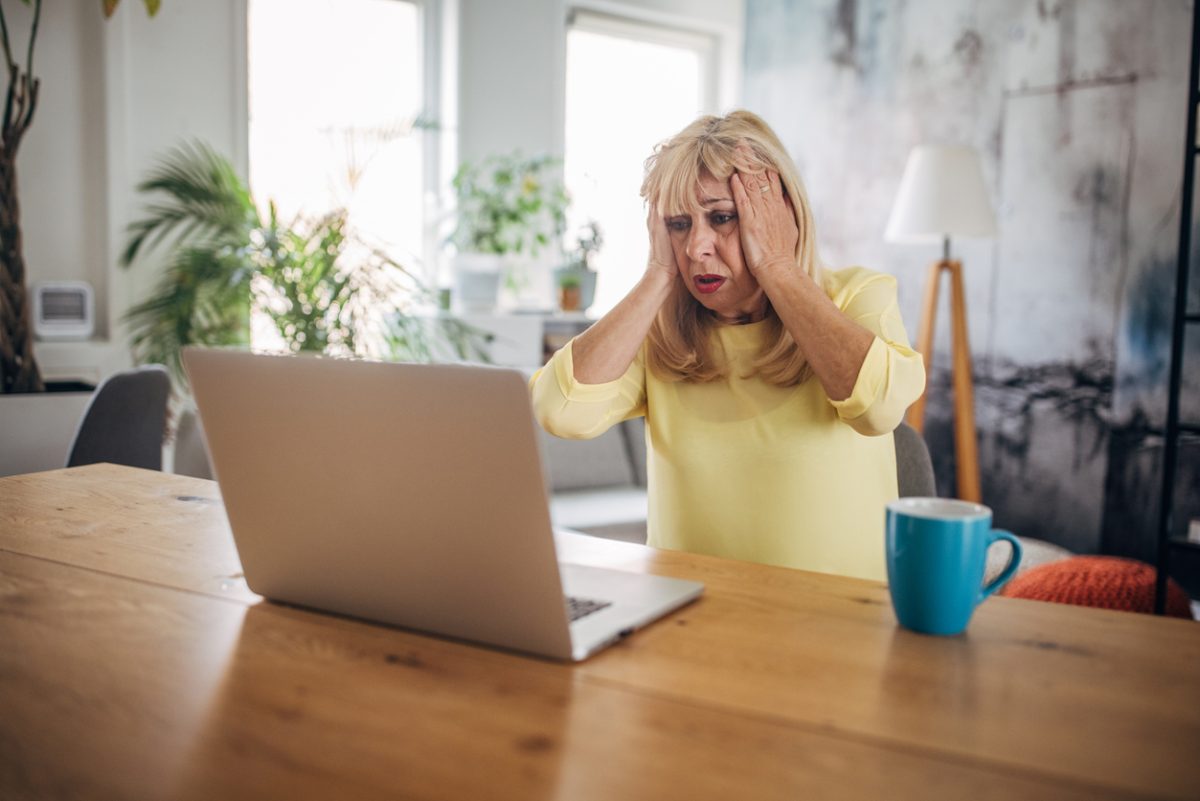 Senior white woman using a laptop and looking worried