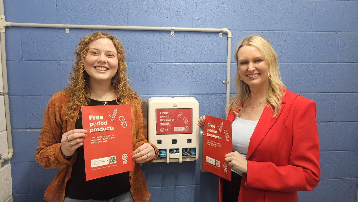 Elia X and Marissa Paterson in front of a period product machine 