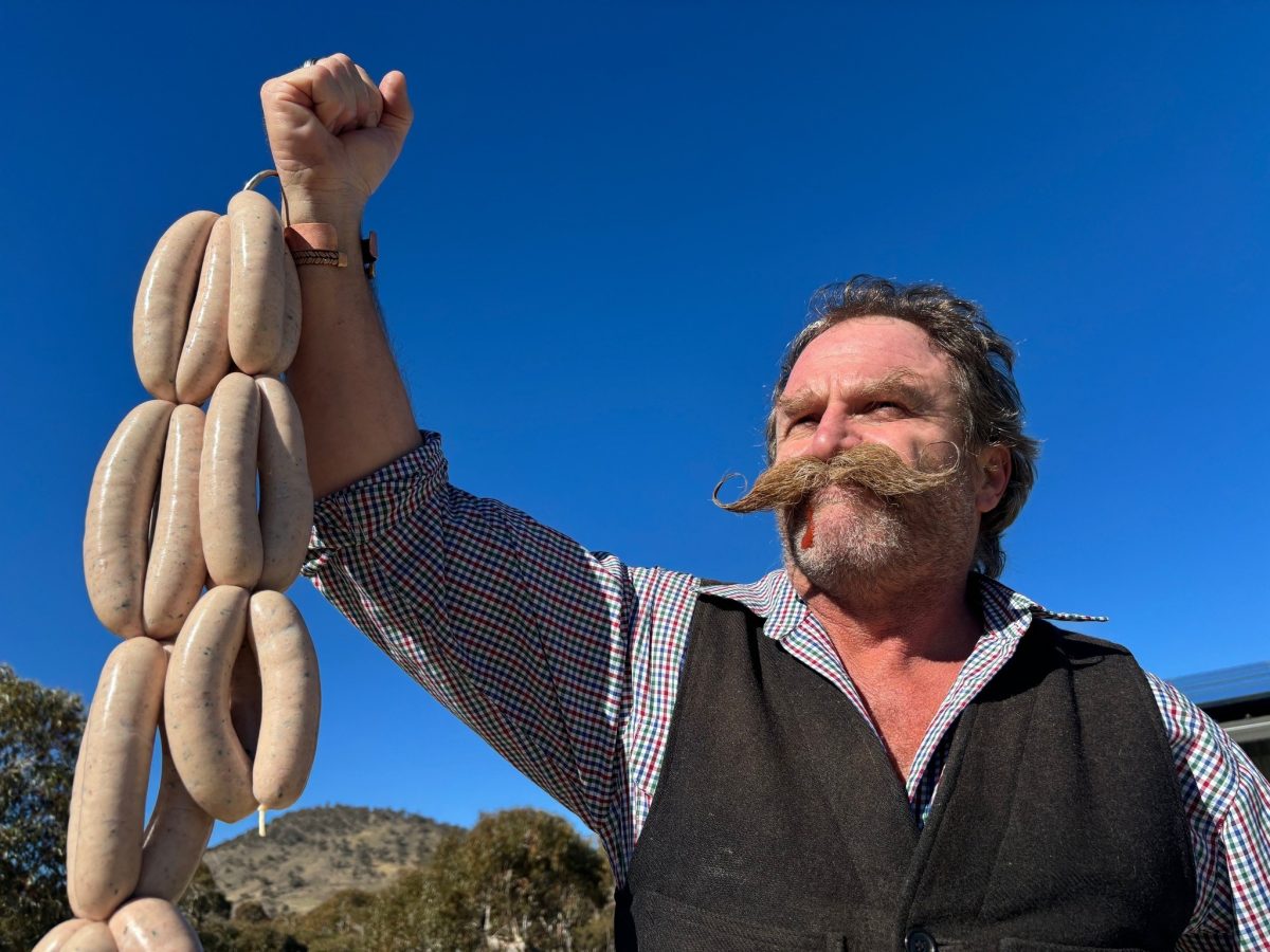 Man holding a string of sausages.