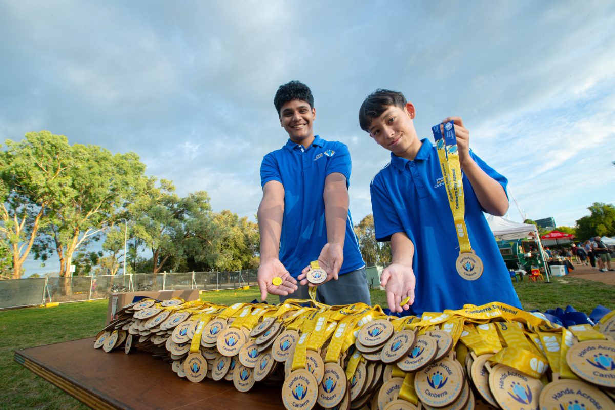 Two boys with a pile of medals