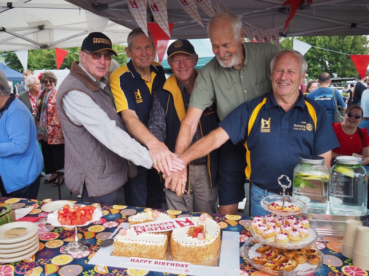 group of men cutting a 20th birthday cake