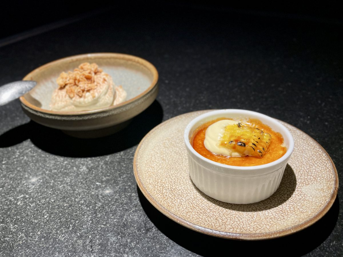 A ramekin of creme brulee with a piece of charred sweet corn on top.