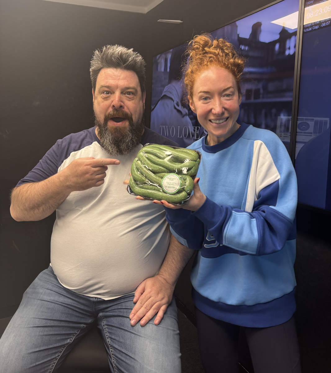 two people holding a package of green sausages