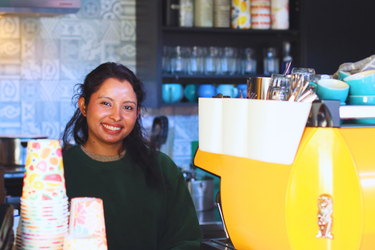 Ashul Thapa smiles from behind cafe counter.