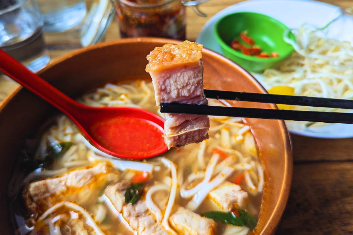 Chopsticks holding pork.