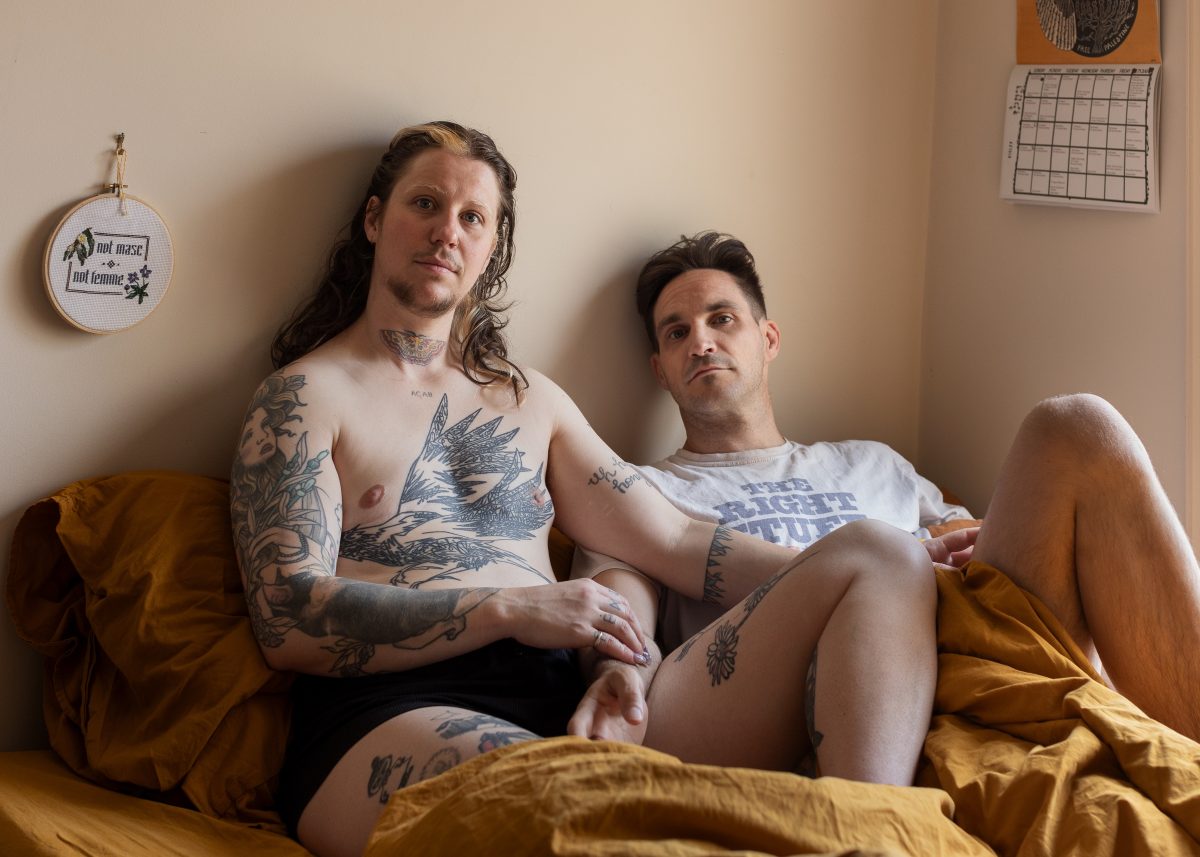 Two men sitting on a bed