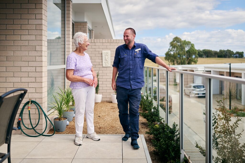 two people standing outside on a balcony