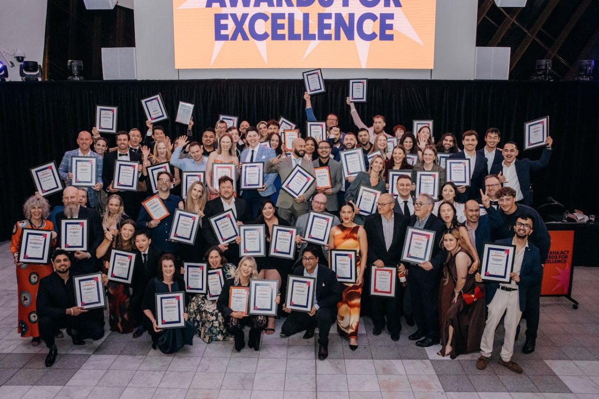 Large group photo of all the winners holding their awards.
