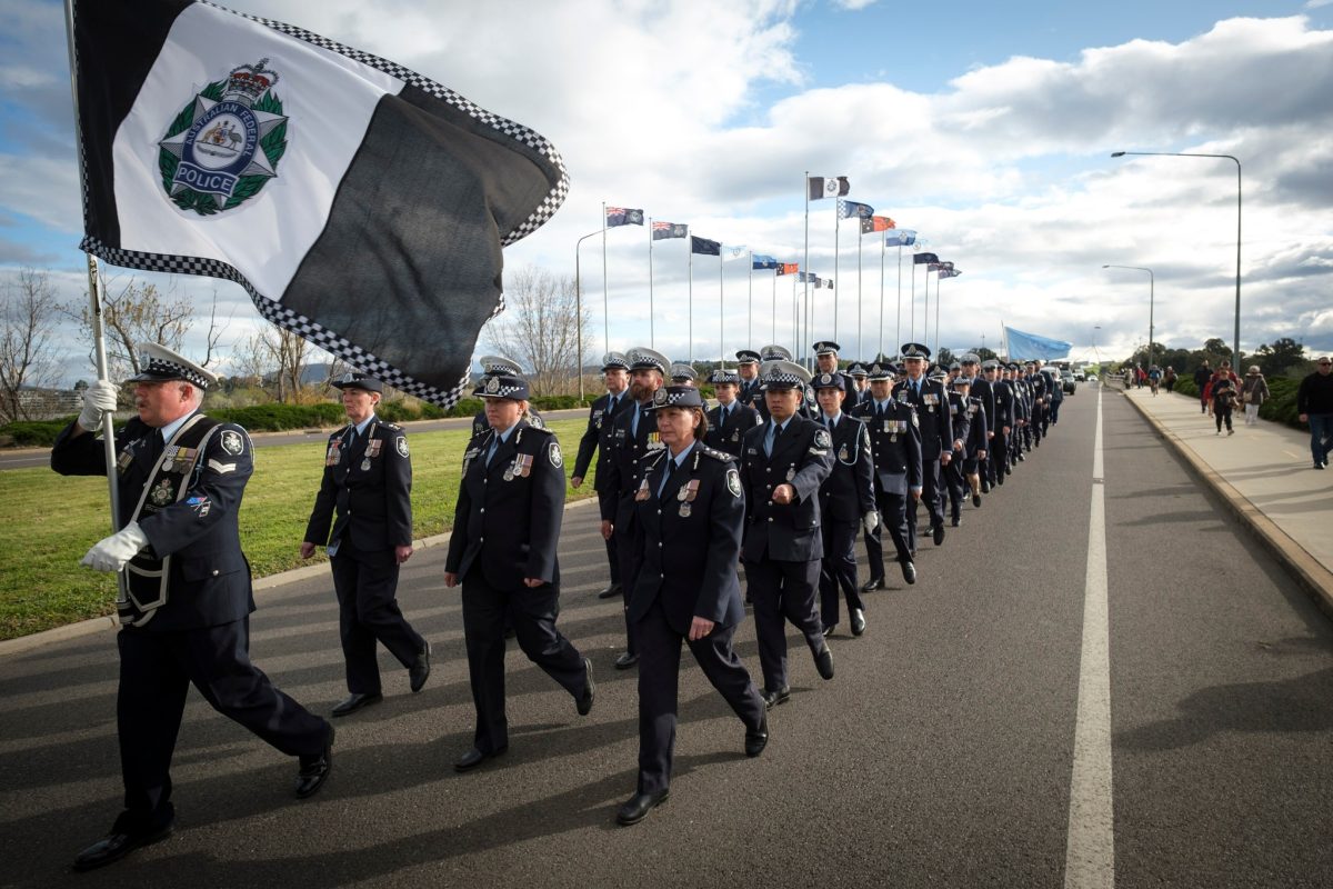 Police walking across bridge with flags