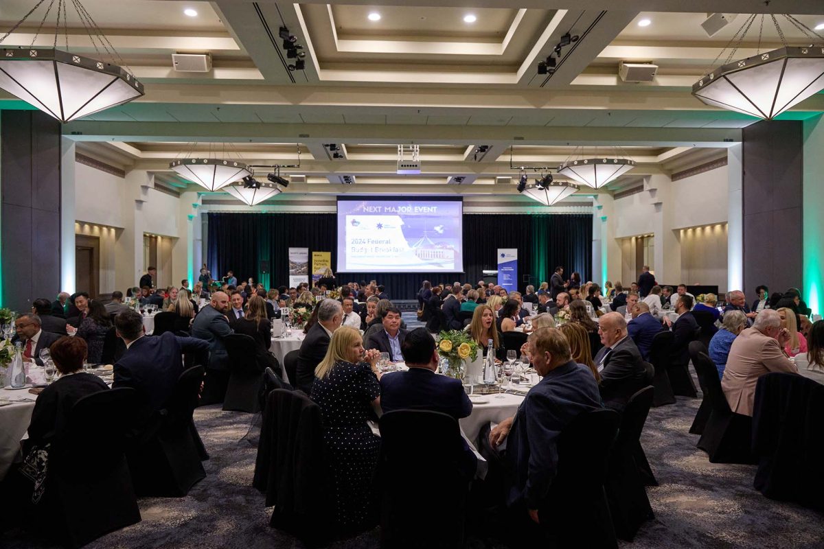 Crowd sits at tables at a function