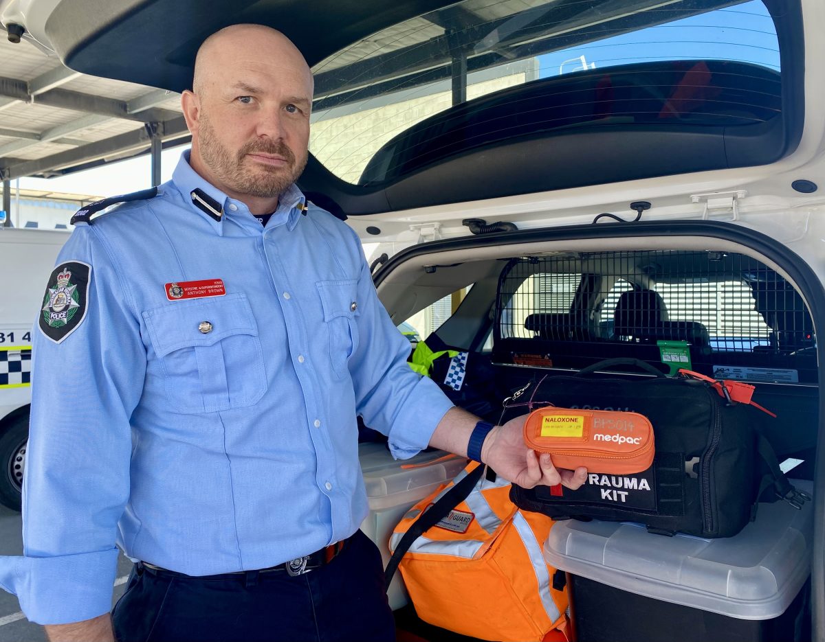police officer holding naloxone first aid kit