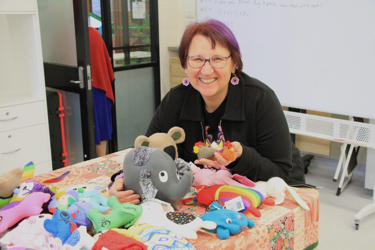Mary sitting with a number of toys Good Omen has made in recent days