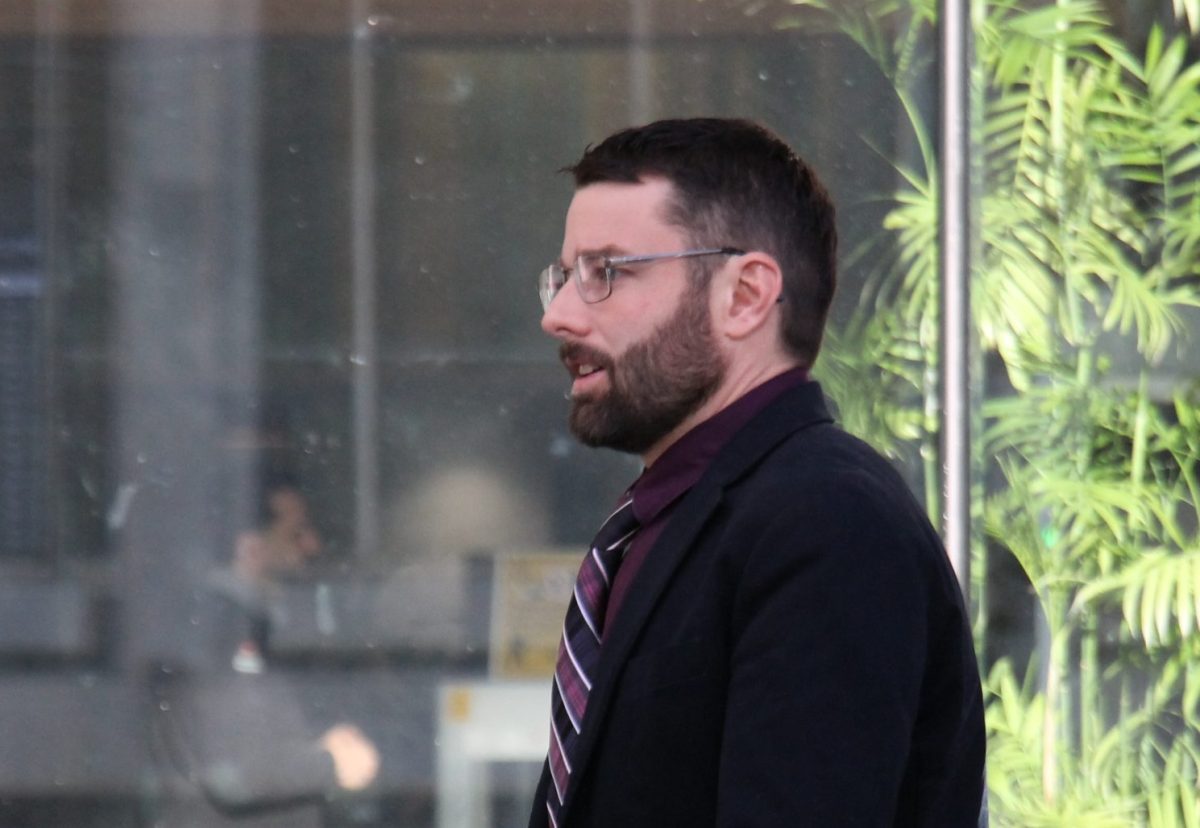 bearded man in a suit walking