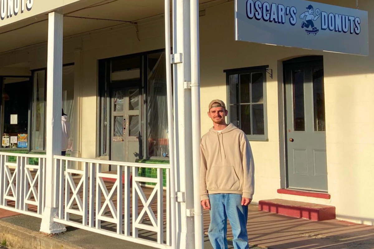 Man stands in front of donut shop.