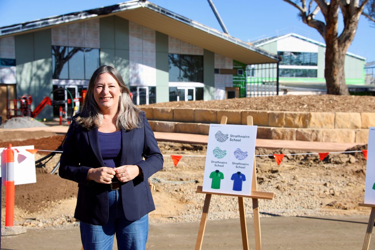 A woman with a display board at a school under construction