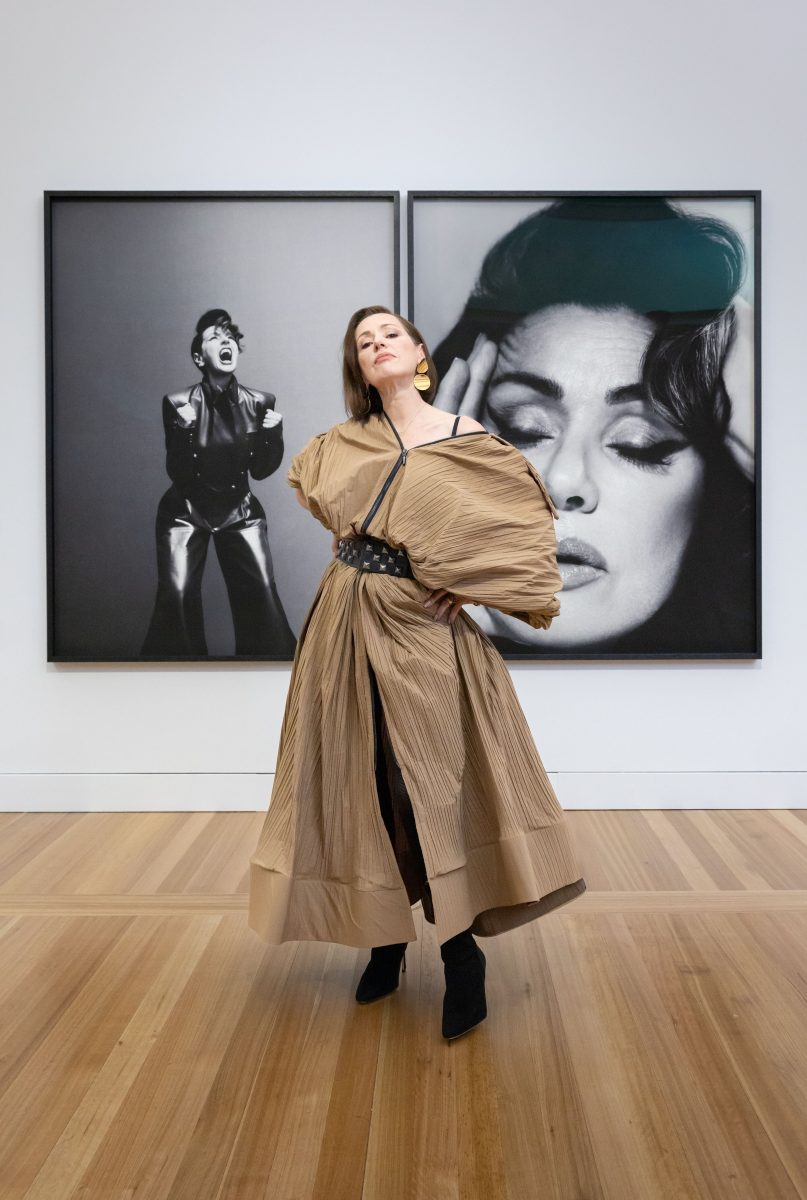 a woman with her portraits in a gallery
