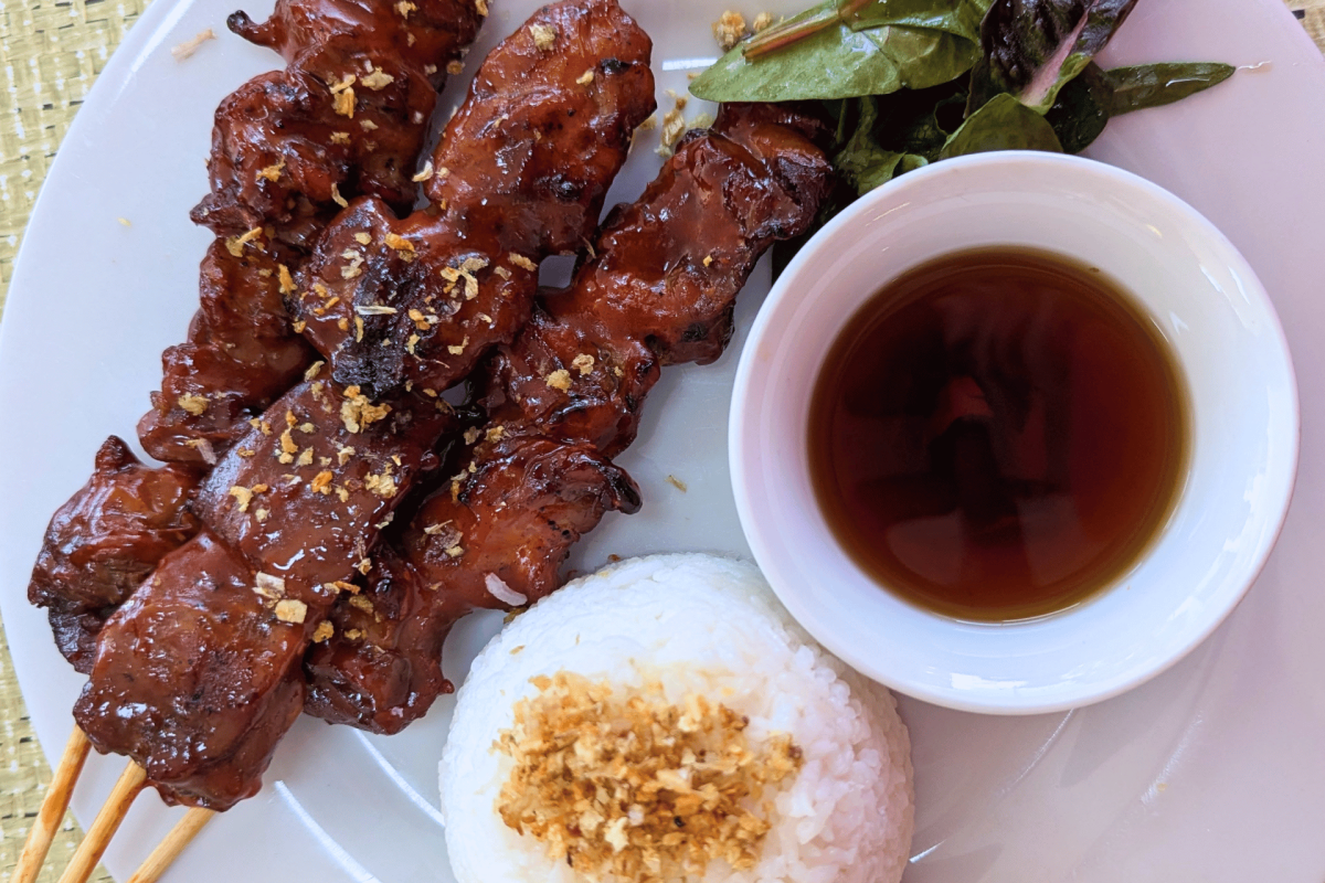 Chicken skewers with rice and dipping sauce.