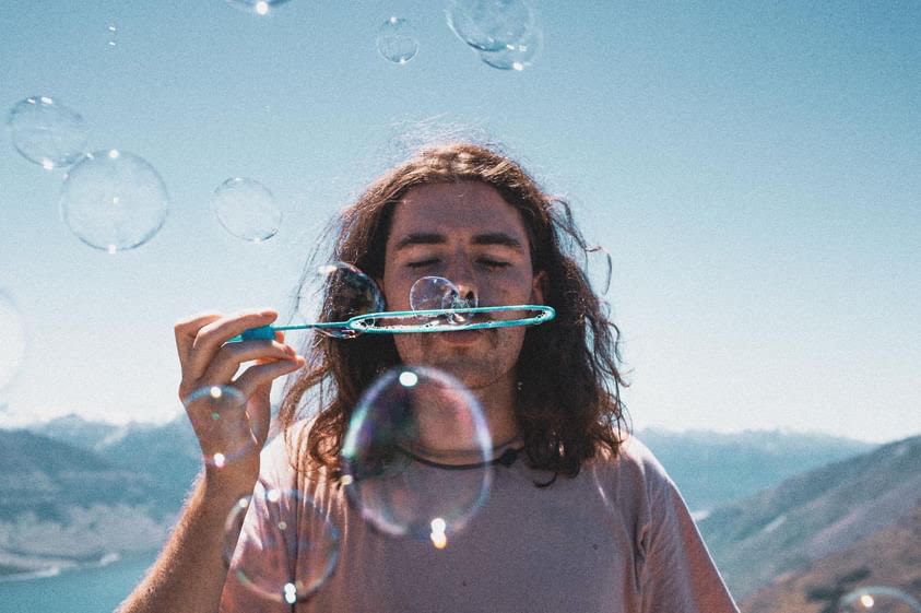 man blowing a bubble