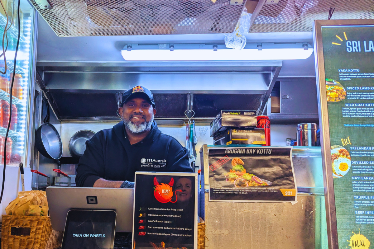 Man standing in food truck smiling at camera.